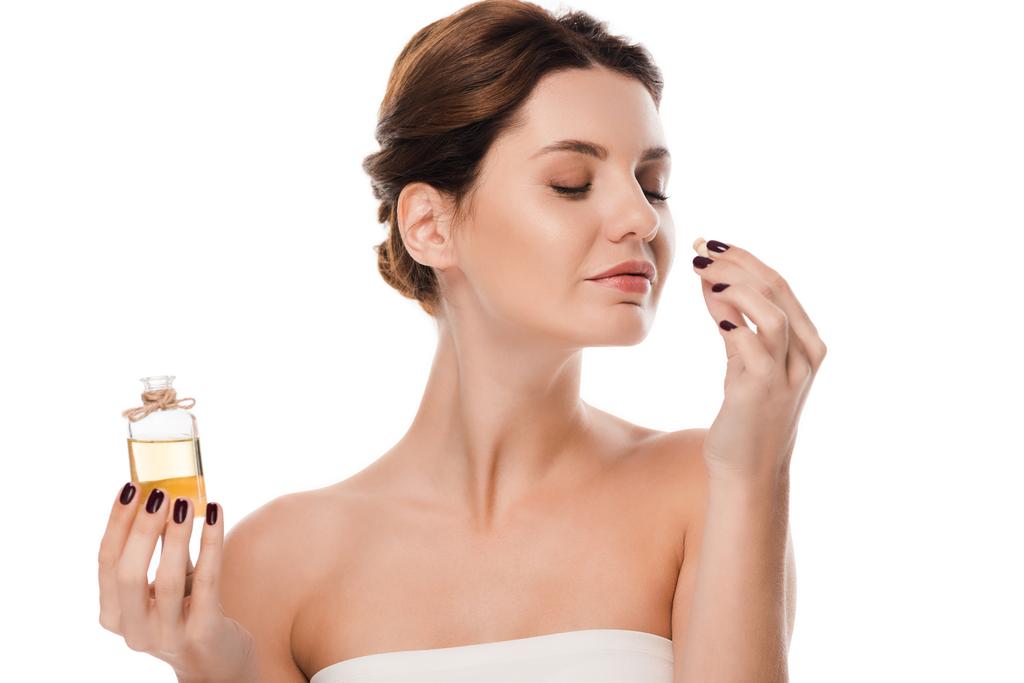 ευτυχισμένη γυναίκα κρατώντας γυάλινη φιάλη και άρωμα μυρωδιά απομονώνονται σε λευκό  - Φωτογραφία, εικόνα