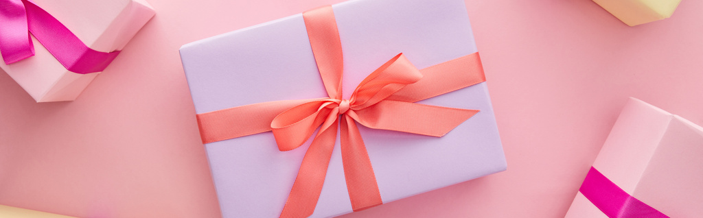 вид сверху на красочные подарочные коробки с лентами и бантами на розовом фоне, панорамный снимок
 - Фото, изображение