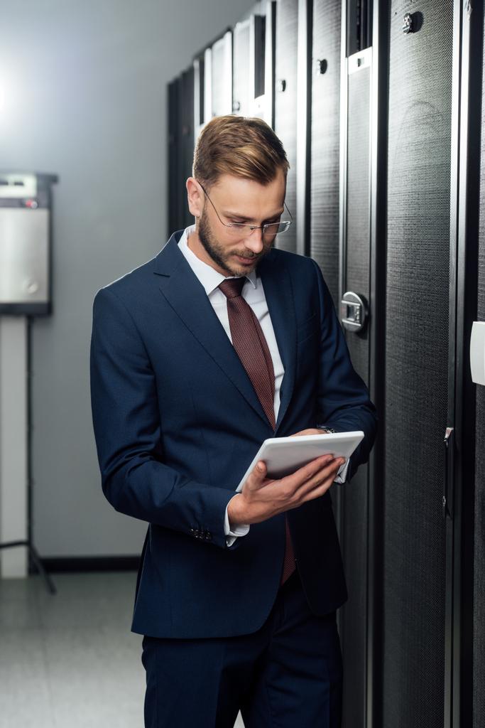 liikemies puku käyttäen digitaalista tabletti datakeskuksessa
  - Valokuva, kuva