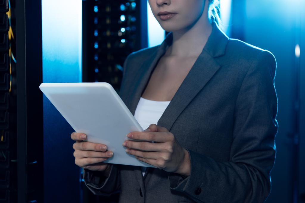 Ausgeschnittene Ansicht einer Geschäftsfrau mit digitalem Tablet im Rechenzentrum  - Foto, Bild