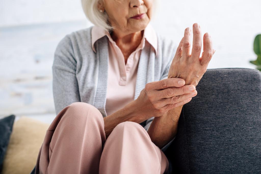 Ausgeschnittener Blick auf Seniorin mit Arthritis in Wohnung  - Foto, Bild