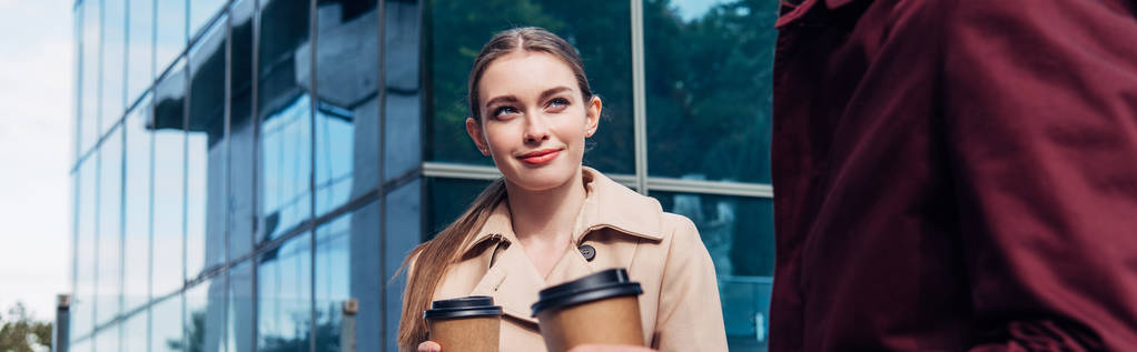 panoramiczne ujęcie atrakcyjnej kobiety patrząc na mężczyznę z kawą na wynos  - Zdjęcie, obraz