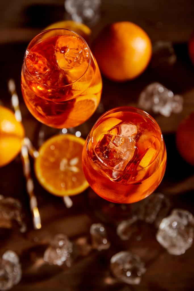 ylhäältä näkymä Aperol Spritz lasit, appelsiinit ja jääkuutiot
  - Valokuva, kuva