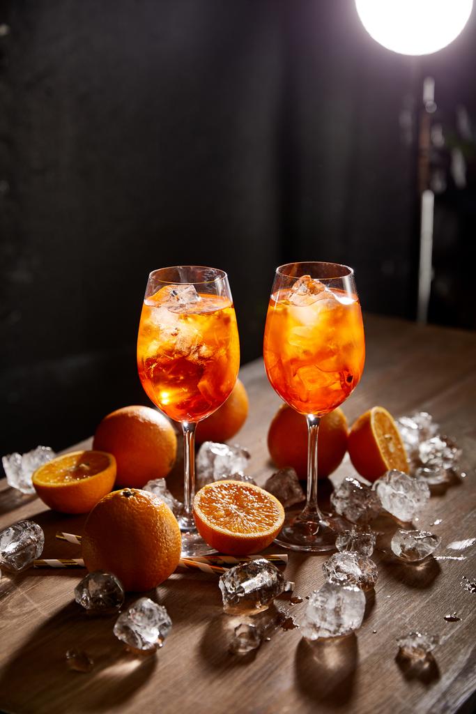 Aperol Spritz en verres, oranges et glaçons sur fond noir
  - Photo, image
