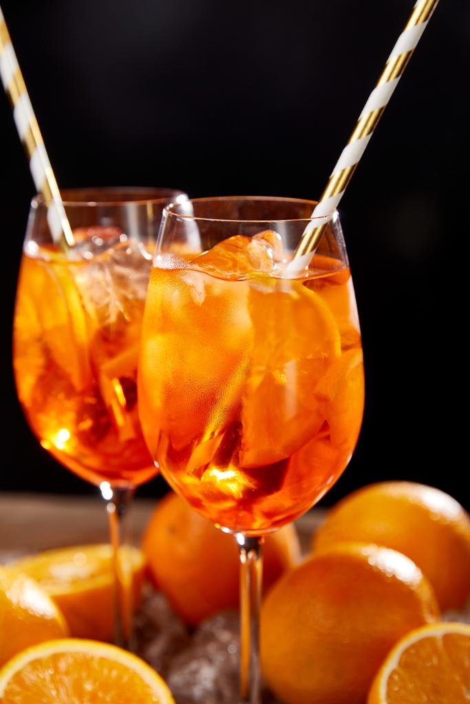 Aperol Spritz en gafas y naranjas sobre fondo negro
  - Foto, imagen