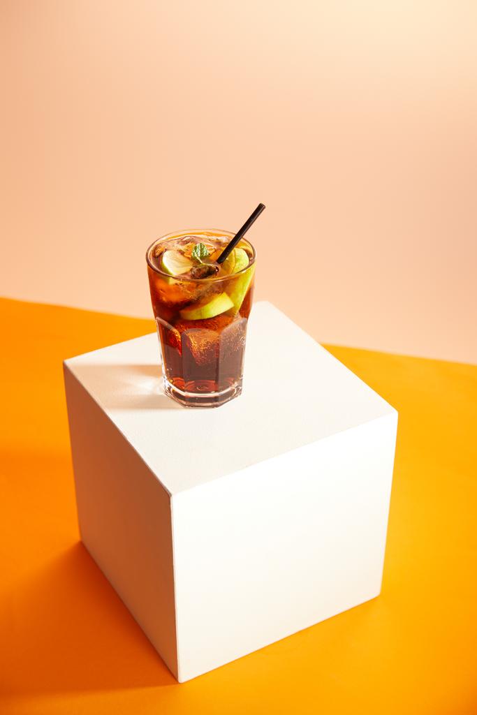 cocktail cuba libre in glas met stro op kubus   - Foto, afbeelding