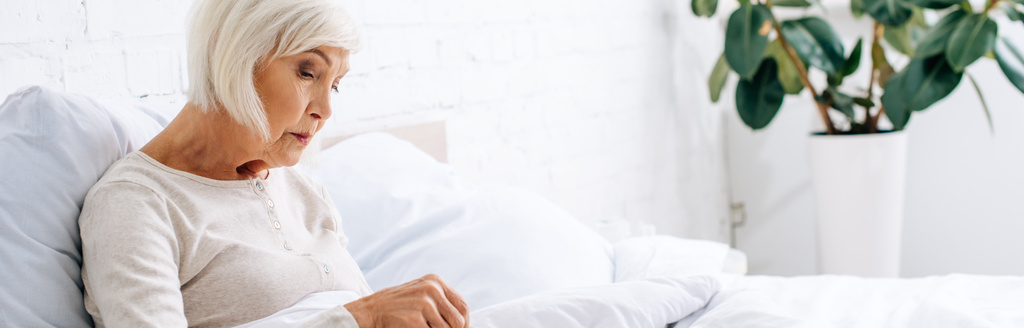 панорамный снимок привлекательной и пожилой женщины в постели
  - Фото, изображение
