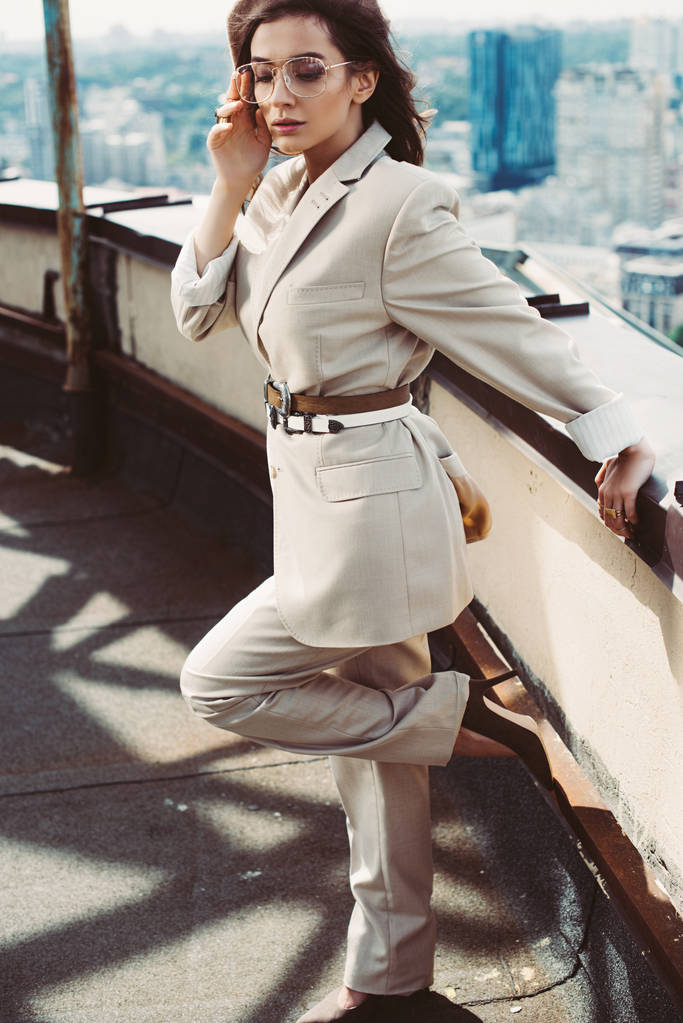 atrakcyjne stylowe eleganckie kobieta pozowanie w beżowy garnitur i beret na dachu - Zdjęcie, obraz