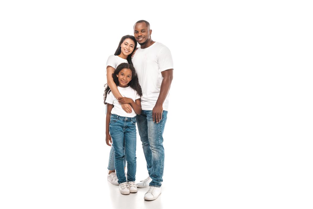 happy african american woman hugging adorable daughter while standing near smiling husband on white background - Photo, Image