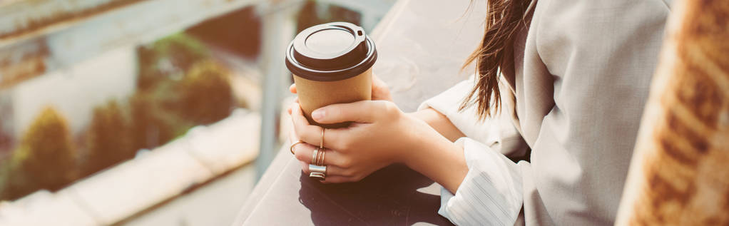 oříznutý pohled na módní dívku v béžovém obleku pózující na střeše s kávou jít - Fotografie, Obrázek
