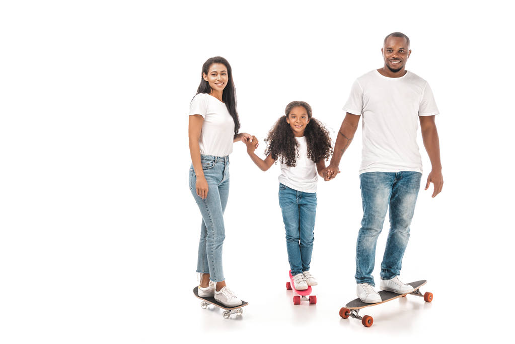 Χαρούμενη αφρικάνικη αμερικανική οικογένεια που στέκεται στο longboard, skate και penny board και κρατά τα χέρια στο λευκό φόντο - Φωτογραφία, εικόνα