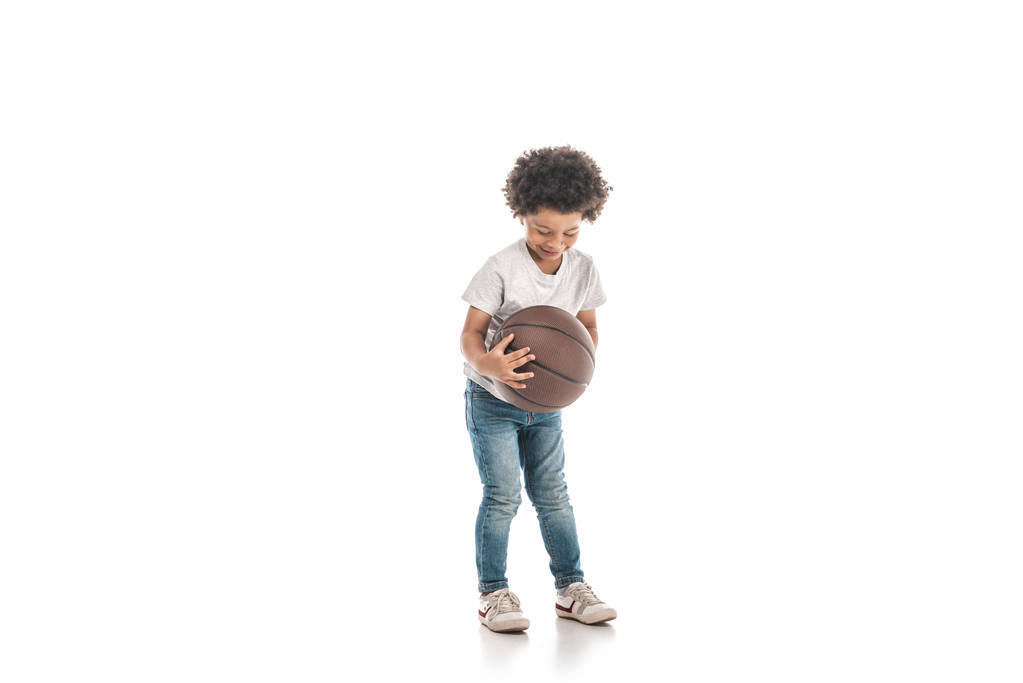 白い背景でバスケットボールをしてる可愛いアフリカ系アメリカ人の少年 - 写真・画像