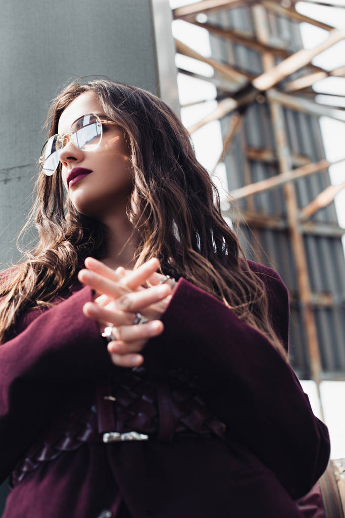 elegáns lány pózol trendi burgundi öltöny és napszemüveg a városi tetőn  - Fotó, kép