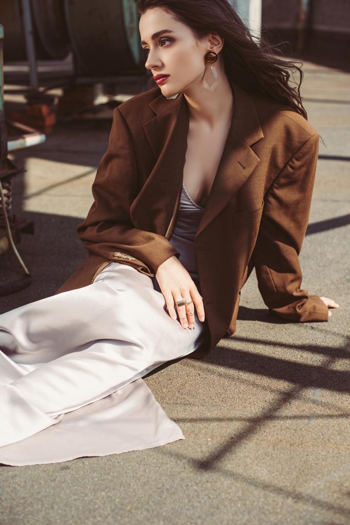 hermosa mujer elegante posando en vestido de seda y chaqueta marrón en el techo
 - Foto, imagen