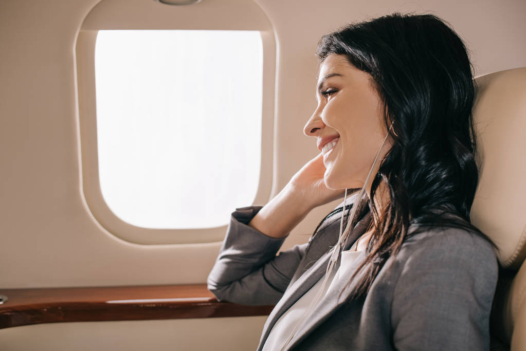 felice donna d'affari ascoltare musica in jet privato
  - Foto, immagini