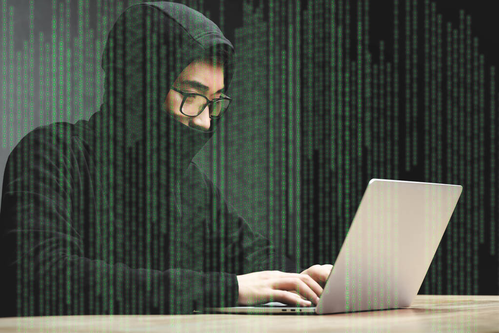 азиатский хакер в очках сидит за столом, используя ноутбук и окружен иллюстрацией
  - Фото, изображение