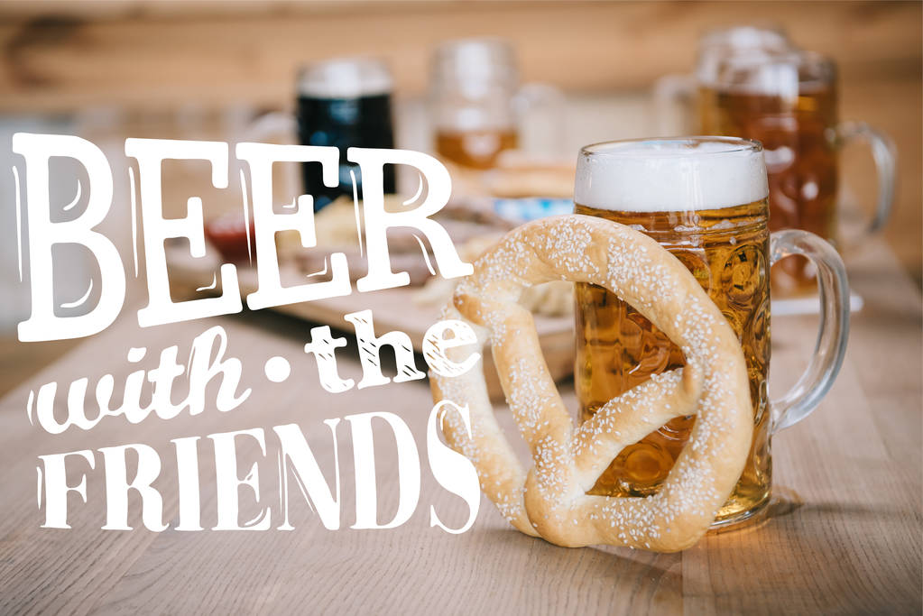 揚げソーセージ、玉ねぎリング、フライドポテト、プレッツェル、マグカップの上からの眺め友人のイラストとビールとパブで木製のテーブルの上でビール - 写真・画像
