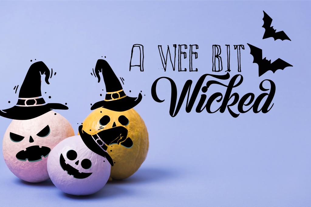 painted festive Halloween pumpkins on violet background with a wee bit wicked illustration - Photo, Image