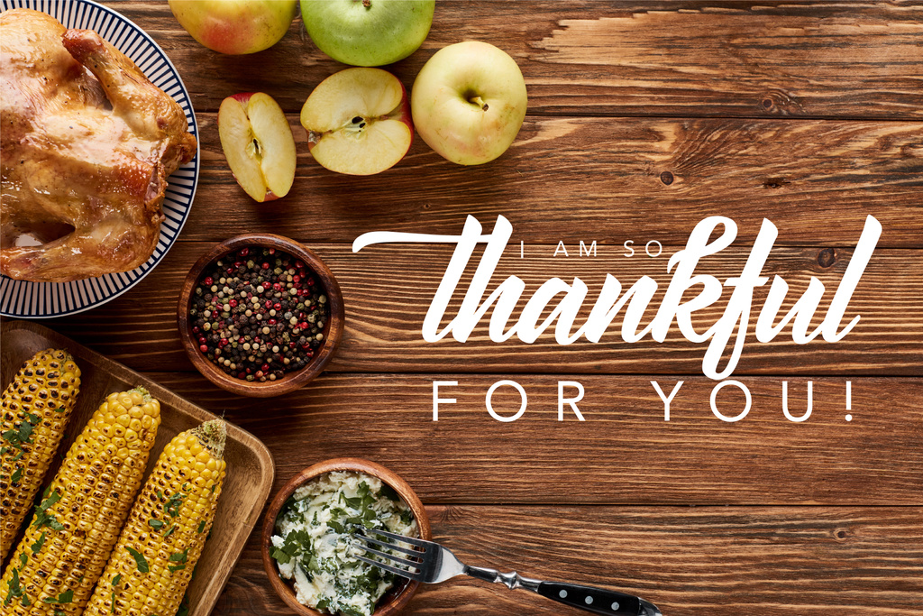 top view of roasted turkey and grilled corn with apples served on wooden table with i am so thankful for you illustration - Photo, Image