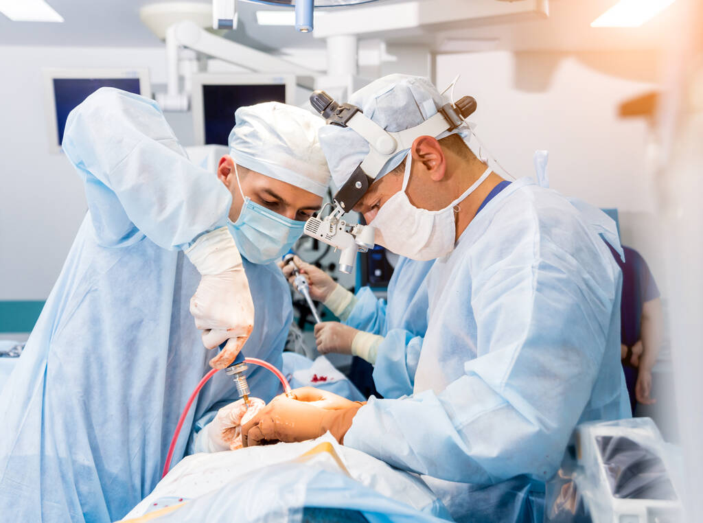 Chirurgia spinale. Gruppo di chirurghi in sala operatoria con attrezzature chirurgiche. Laminectomia. Contesto medico moderno
 - Foto, immagini