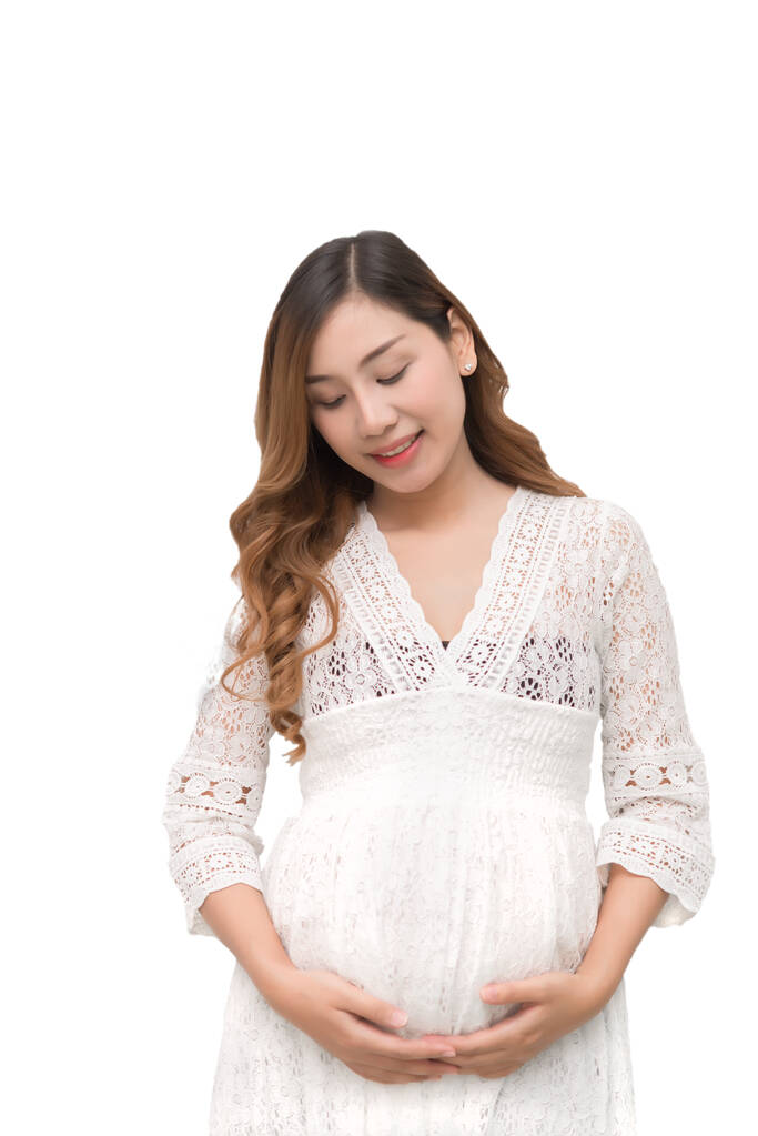 zwanger vrouw in wit jurk aanraken op haar buik op witte achtergrond, aziatische vrouw, dit heeft clipping pad - Foto, afbeelding