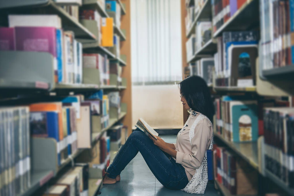 Bela mulher asiática usar óculos olhando um livro na biblioteca - Foto, Imagem