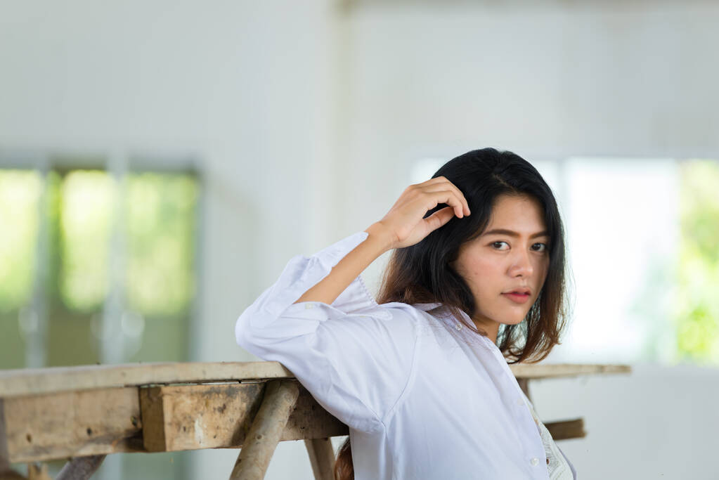 Porträt einer sinnlichen asiatischen Frau mit weißem Hemd, die in einem alten Gebäude in Thailand posiert , - Foto, Bild