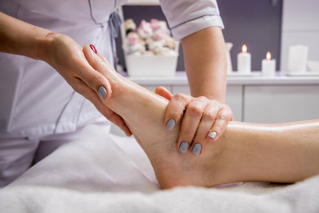 Krásná mladá žena si užívá masáž nohou v lázeňském salonu. Koncept kosmetologie - Fotografie, Obrázek