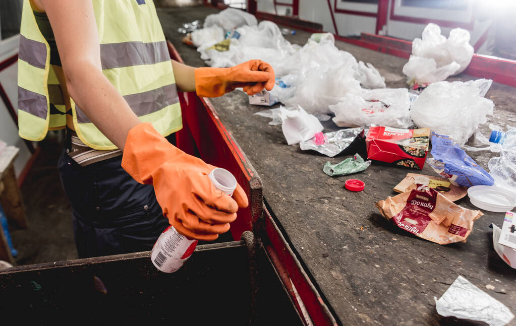 Arbeiter trennen Müllabfuhr an moderner Recyclinganlage - Foto, Bild
