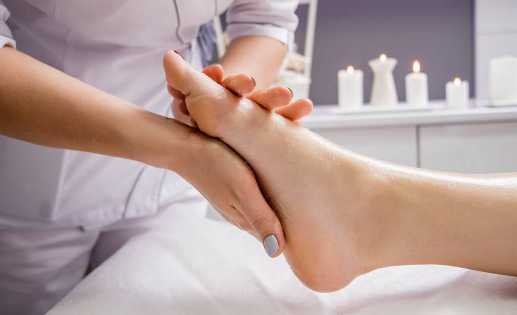 Mulher bonita desfrutando de massagem nos pés no salão de spa. Conceito de cosmetologia
 - Foto, Imagem