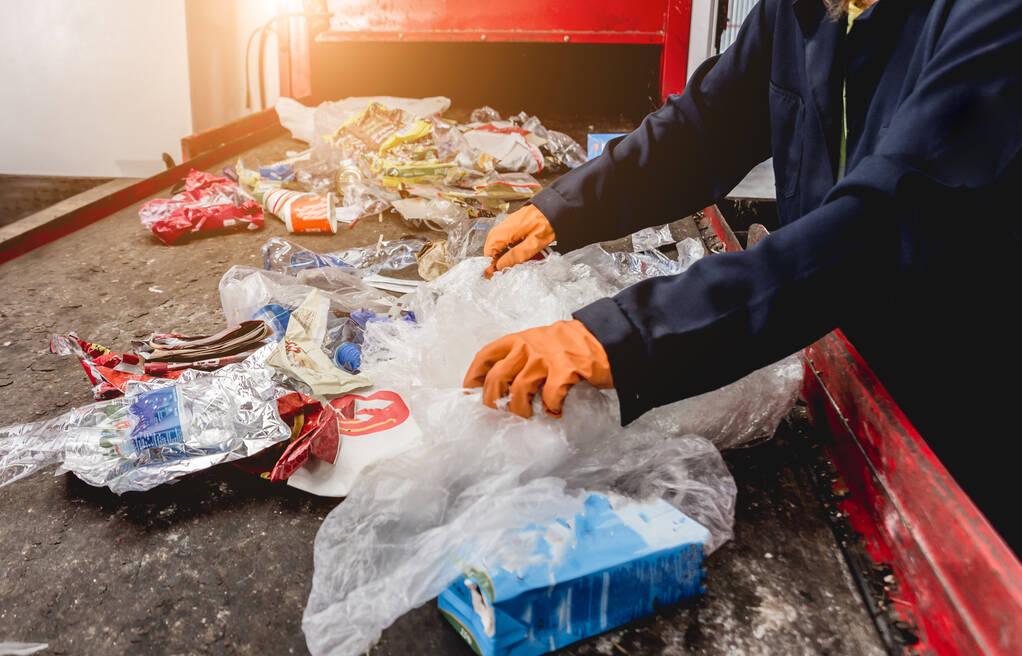 Εργαζόμενος που διαχωρίζει τη συλλογή απορριμμάτων σε σύγχρονες εγκαταστάσεις ανακύκλωσης - Φωτογραφία, εικόνα