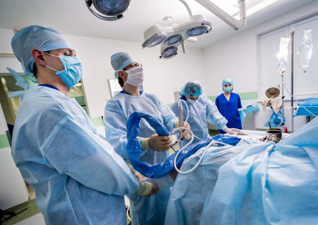 Cirugía de artroscopio. Cirujanos ortopédicos en equipo en quirófano con modernas herramientas artroscópicas. Cirugía de rodilla. Fondo hospitalario - Foto, imagen