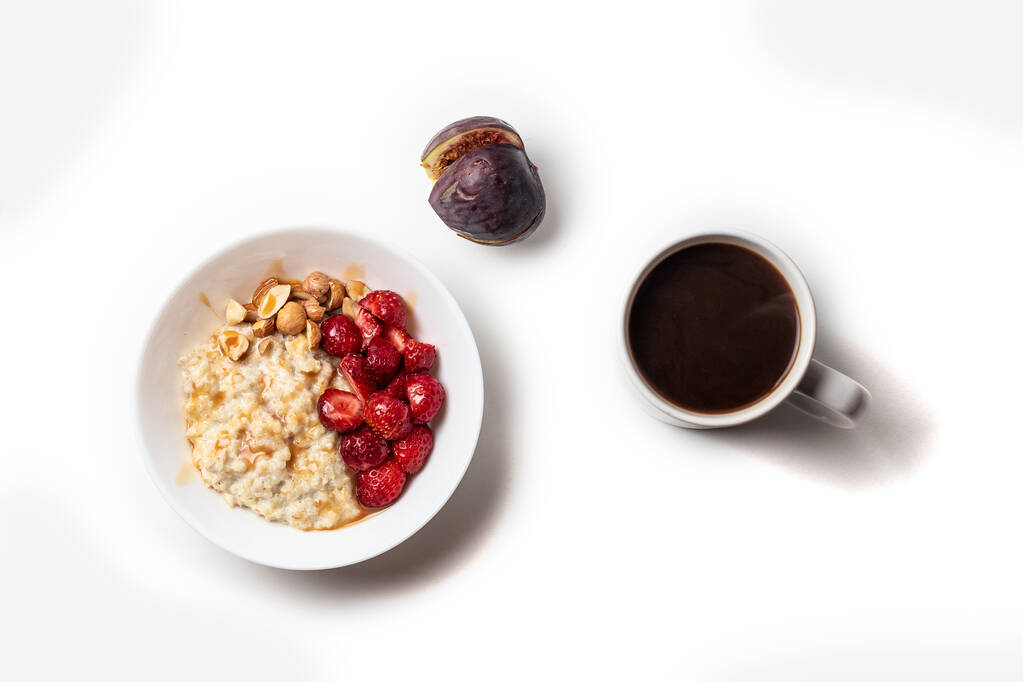Frühstück Haferbrei mit Früchten Beeren und Kaffeetasse. Konzept für gesundes Frühstück - Foto, Bild