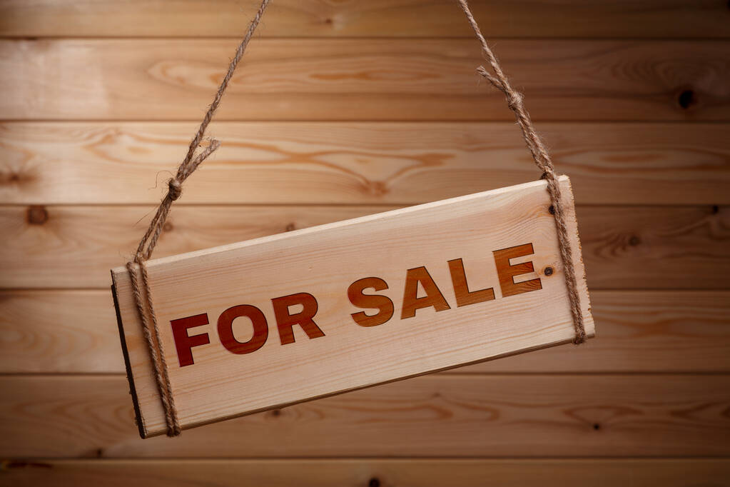 Ξύλινη πινακίδα με τις λέξεις προς πώληση σε ένα τραχύ σχοινί σε ένα όμορφο ξύλινο φόντο - Φωτογραφία, εικόνα