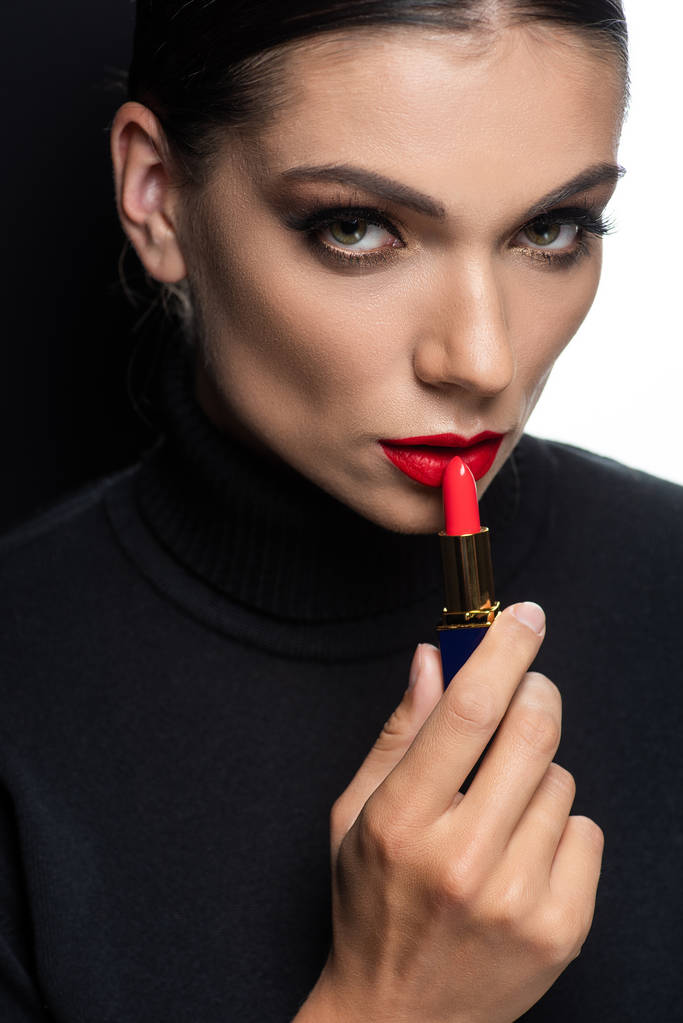 όμορφη γυναίκα με κόκκινα χείλη εφαρμογή κραγιόν απομονώνονται σε λευκό και μαύρο - Φωτογραφία, εικόνα