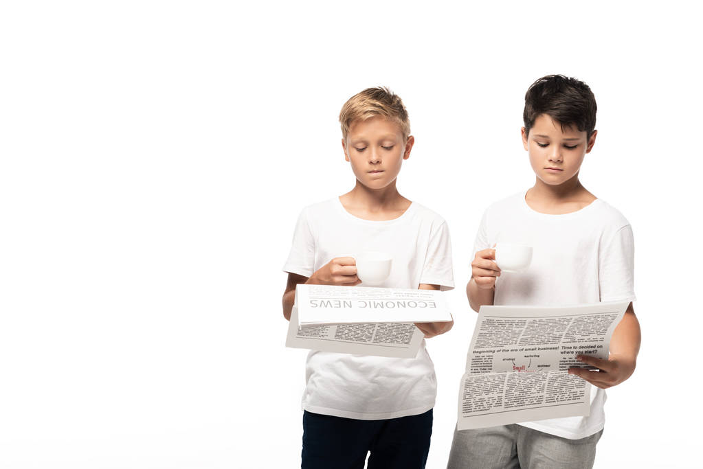 kaksi vakavaa poikaa lukemassa sanomalehtiä pitäen kahvikuppeja eristyksissä valkoisella
 - Valokuva, kuva