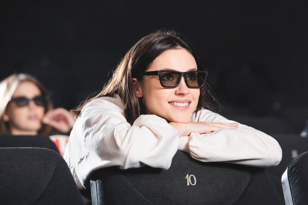 selectieve focus van lachende vrouw in 3D bril kijken film in de bioscoop  - Foto, afbeelding