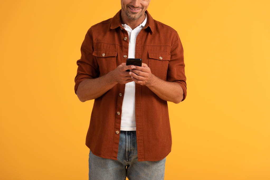 обрізаний вид щасливого чоловіка за допомогою смартфона ізольовано на помаранчевому
  - Фото, зображення