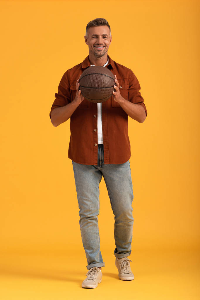 uomo felice che tiene il basket su arancione
  - Foto, immagini