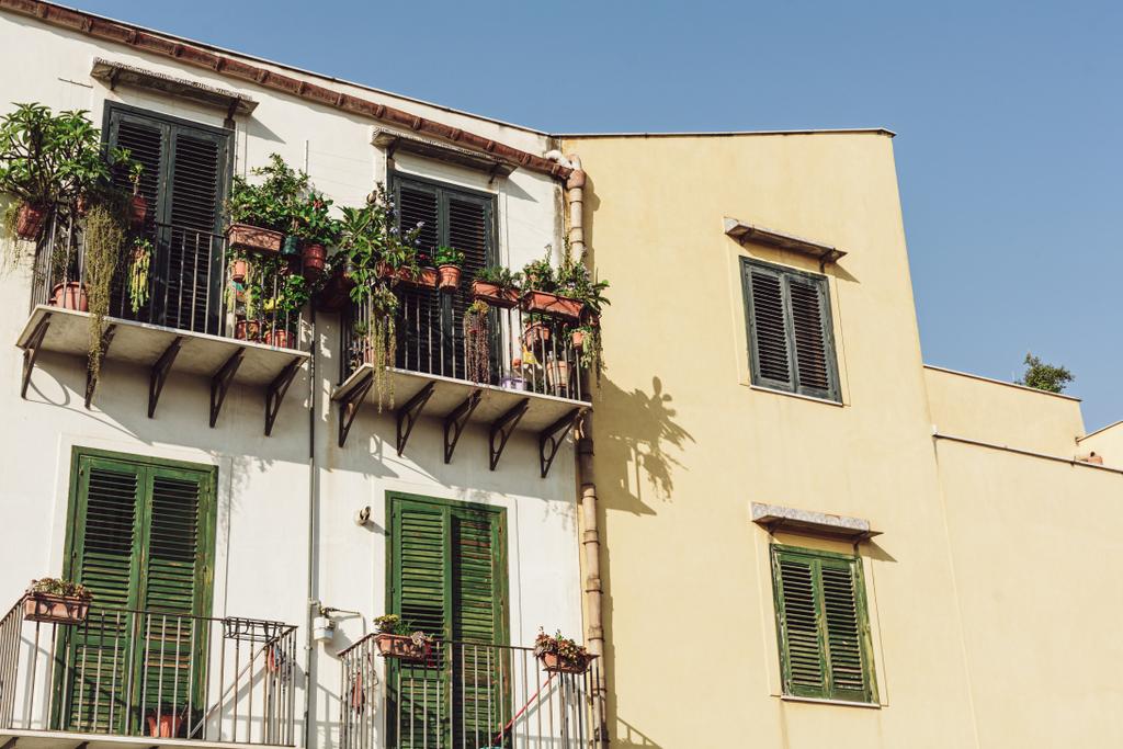 Gebäude mit Fenstern und Pflanzen auf Balkonen in Italien  - Foto, Bild
