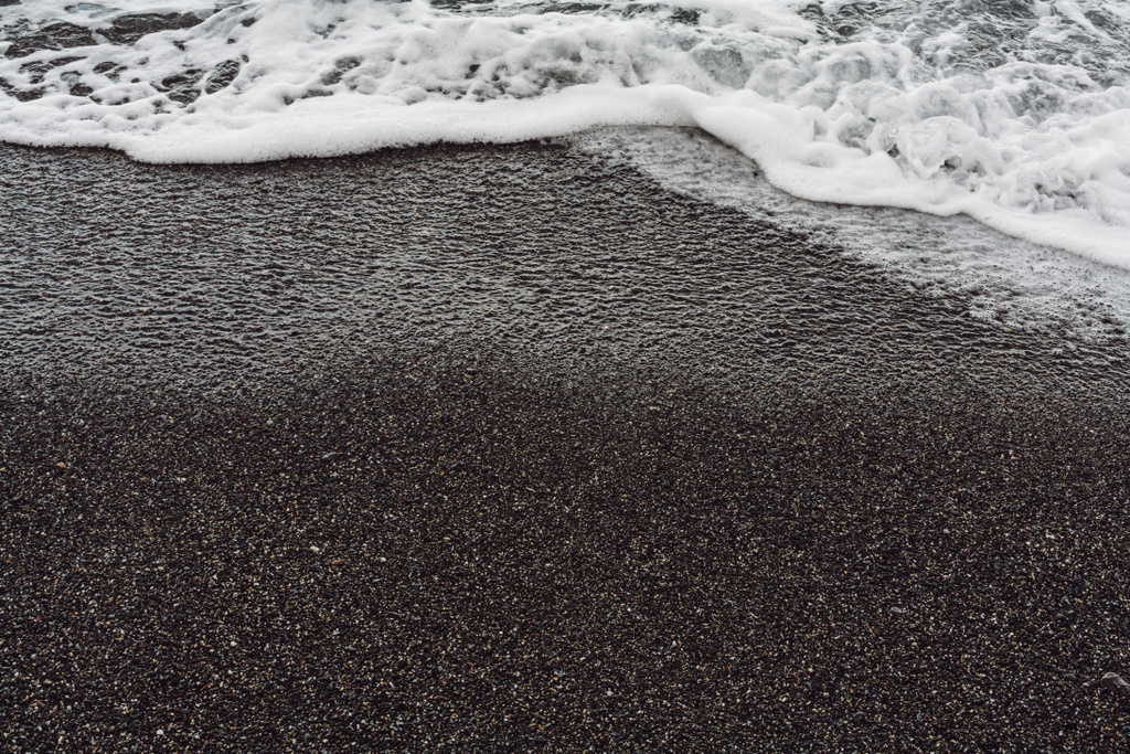 white sea foam on wet sandy beach  - Photo, Image