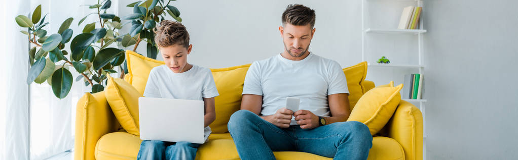 panoramic shot of father and son using gadgets at home  - Photo, Image
