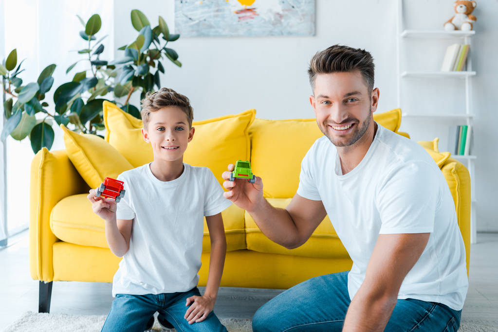 щасливий син і красивий батько грає з іграшковими машинами вдома
  - Фото, зображення