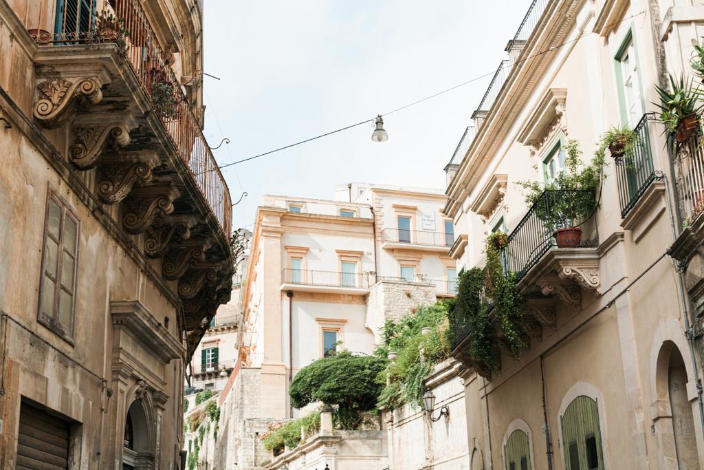 low angle view of plants on balconies of old houses in modica, Italy  - Photo, Image
