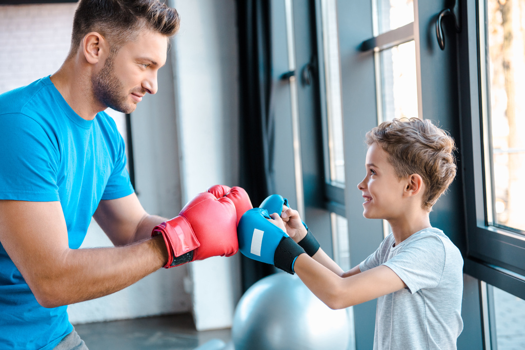 可愛い息子を見てボクシング手袋でハンサムな父親の側のビュー  - 写真・画像