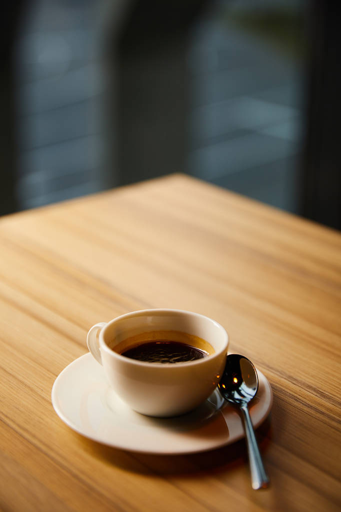 Kafede kaşık yanında kahve olan beyaz fincanın seçici odağı  - Fotoğraf, Görsel