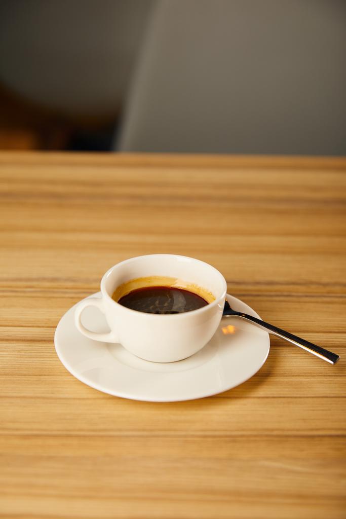 bílý šálek s kávou u lžíce v kavárně  - Fotografie, Obrázek