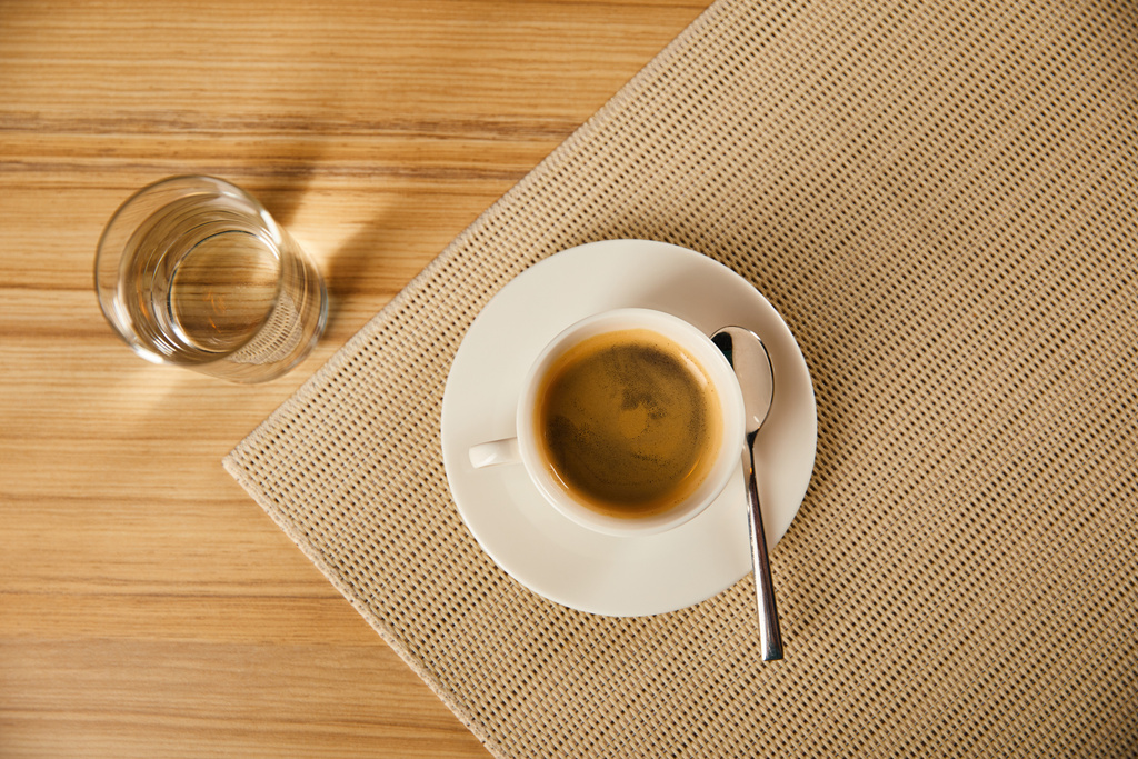 ylhäältä näkymä kuppi kuumalla kahvilla lähellä lasia vedellä kahvilassa
  - Valokuva, kuva