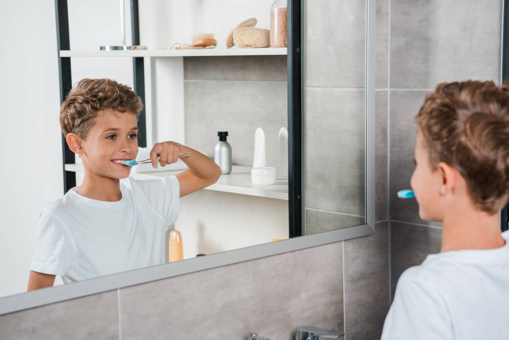 selektywne skupienie szczęśliwego dziecka myjącego zęby w łazience  - Zdjęcie, obraz