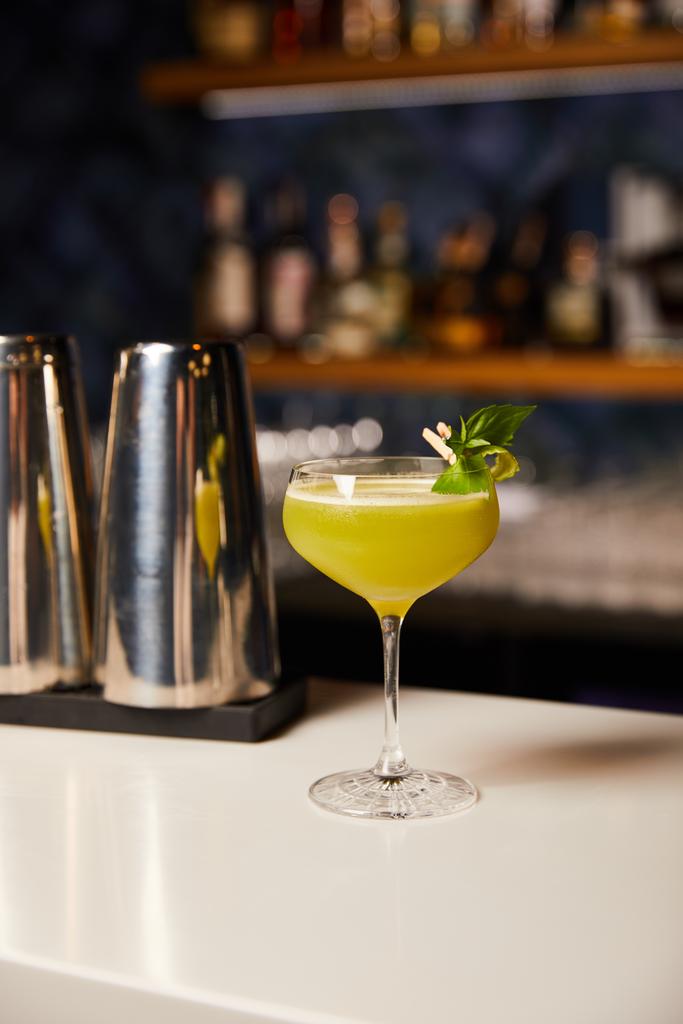 склянка зі змішаним алкогольним коктейлем біля шейкера на барній стійці
  - Фото, зображення